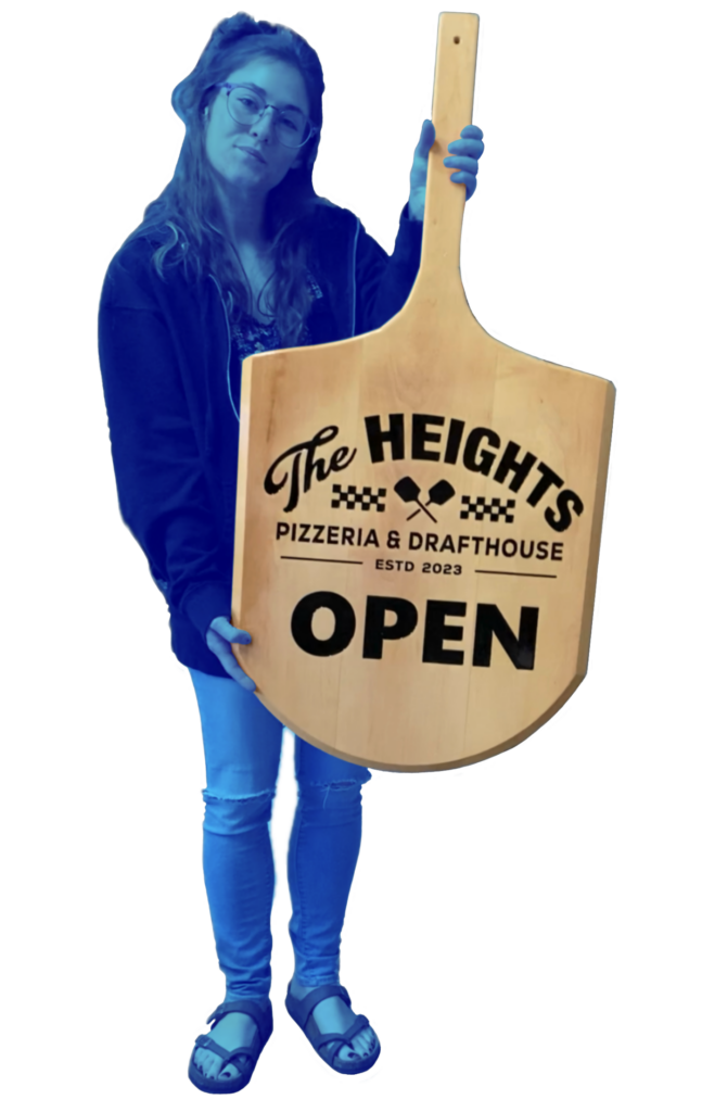 blue tinted photo of a woman holding a wooden sign made from a pizza paddle