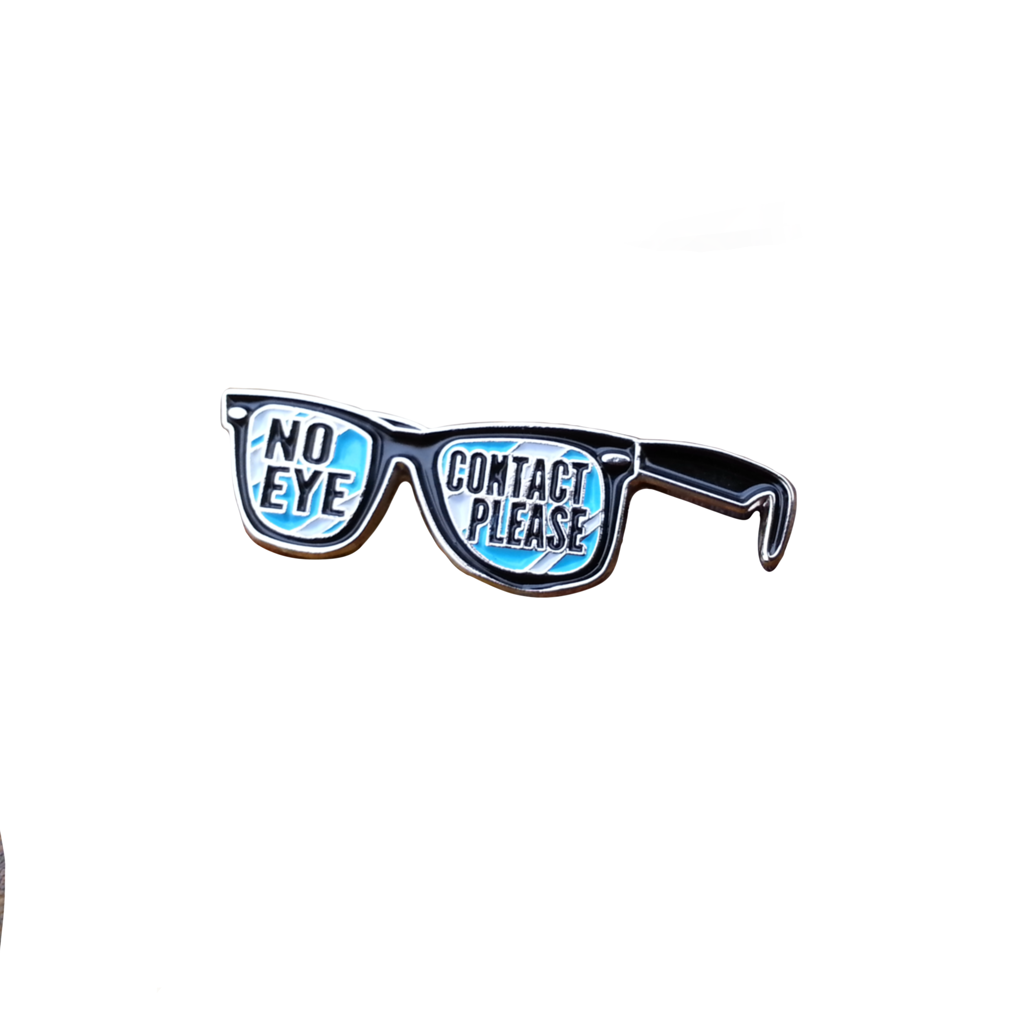 small lapel pin that depict sunglasses with the words "no eye contact please" written on the lenses