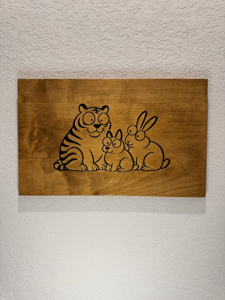 cartoon animals carved into a wooden sign, hanging on a wall